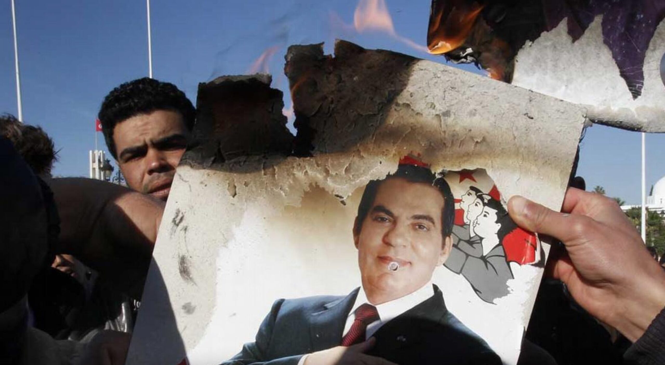 Strikers burn a photo of President Zine El Abidine Ben Ali during a protest